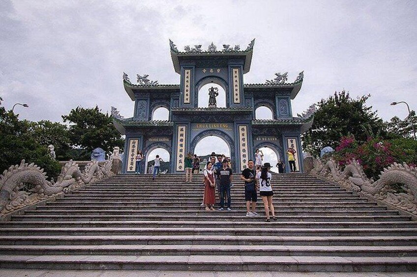 A traditional Chinese gate with intricate carvings and a staircase leading up to it. 4
