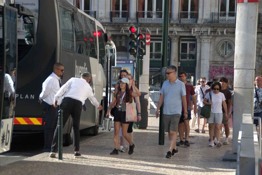 A busy street with pedestrians, a bus, and a traffic light. 5