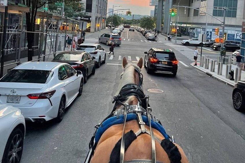 Une calèche tirée par des chevaux dans une rue de la ville, avec des voitures et des piétons. 2