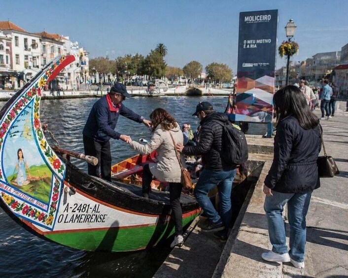A colorful boat with people boarding it, a waterfront, and a cityscape with buildings and a clear sky. 3