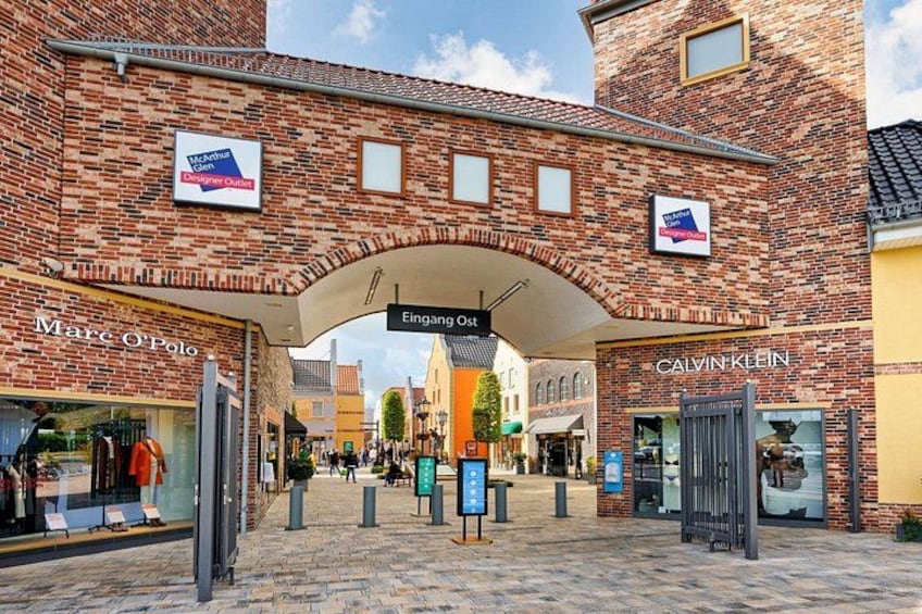 A brick building with storefronts for Marc O'Polo and Calvin Klein. 2