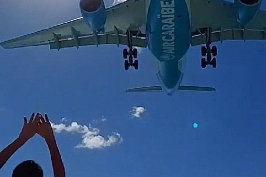 A large aircraft with 'AIRCARIBE' written on its side flying in the sky. 2