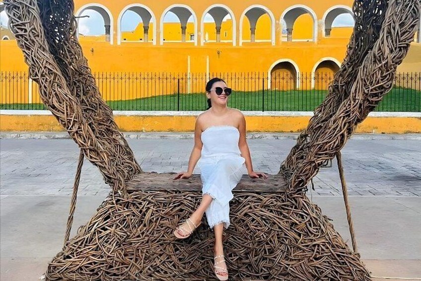 A person standing on a woven structure with a yellow building in the background. 5