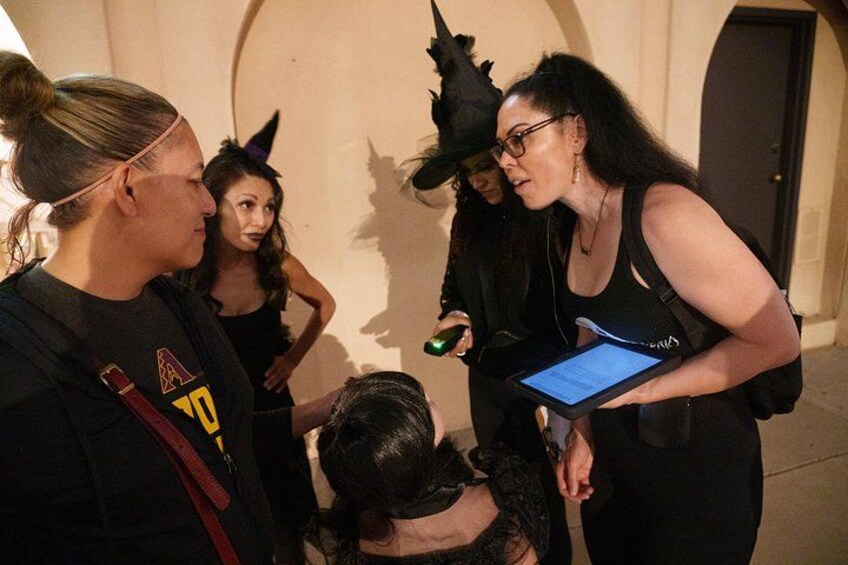 A group of people in a dimly lit indoor setting, some wearing costumes. 4