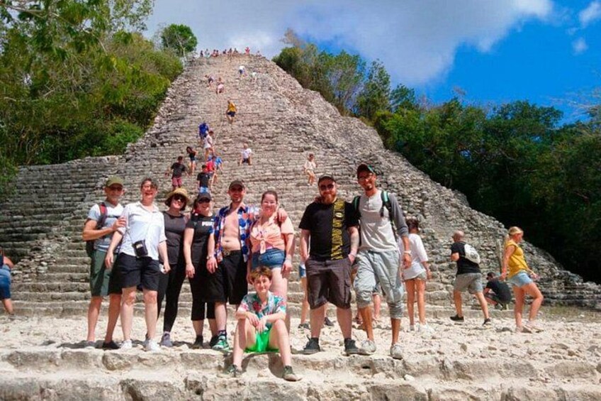 A group of people standing on a stone staircase leading up to a pyramid. 5