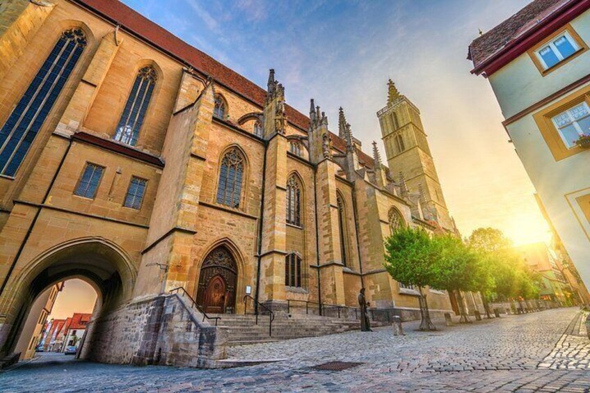 A historic church with a tall bell tower, arched windows, and a cobblestone street. 3