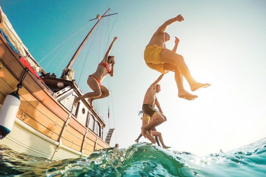 Menschen springen von einem Boot ins Wasser. 2