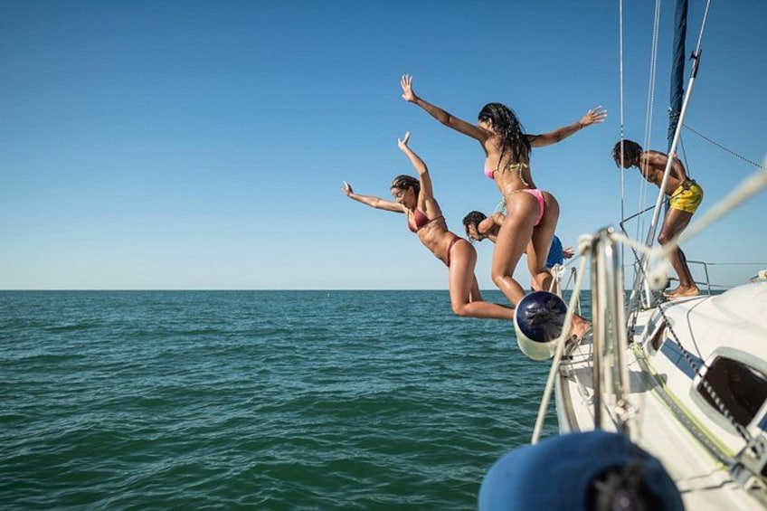 Menschen springen von einem Boot ins Meer. 4