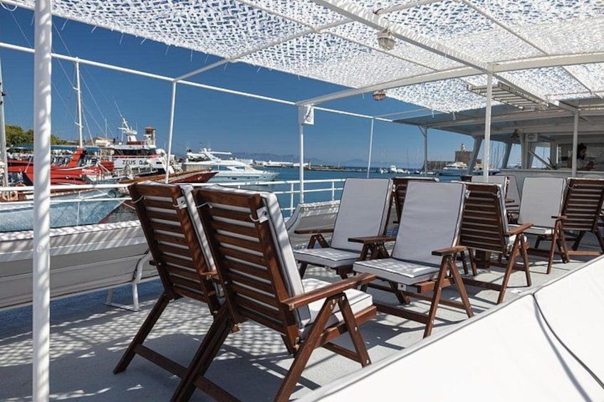 A boat deck with lounge chairs and a white canopy. 5