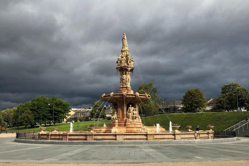 A large, ornate fountain with statues in a park. 3