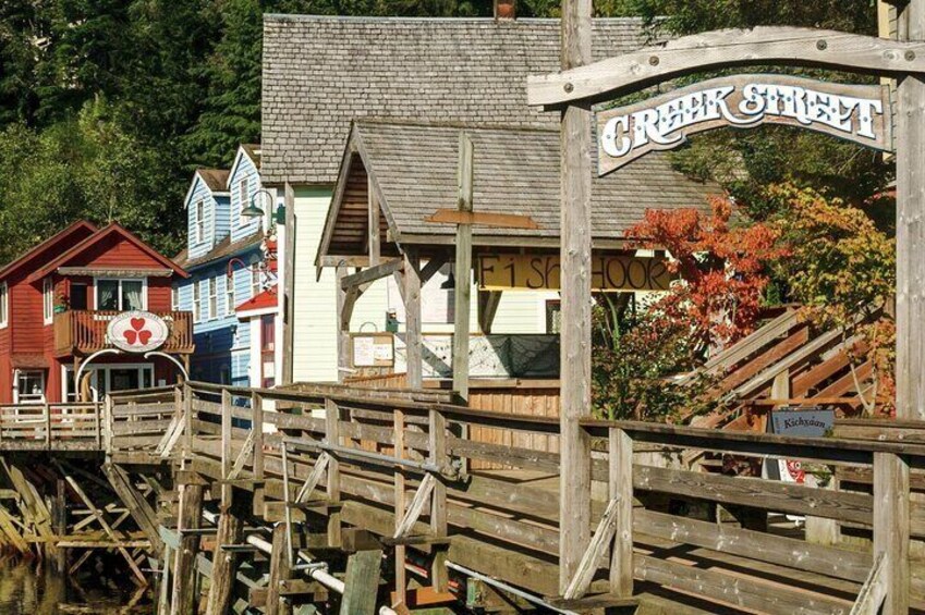 Un muelle de madera que conduce a una hilera de edificios coloridos con un letrero que dice "Creek Street". 1