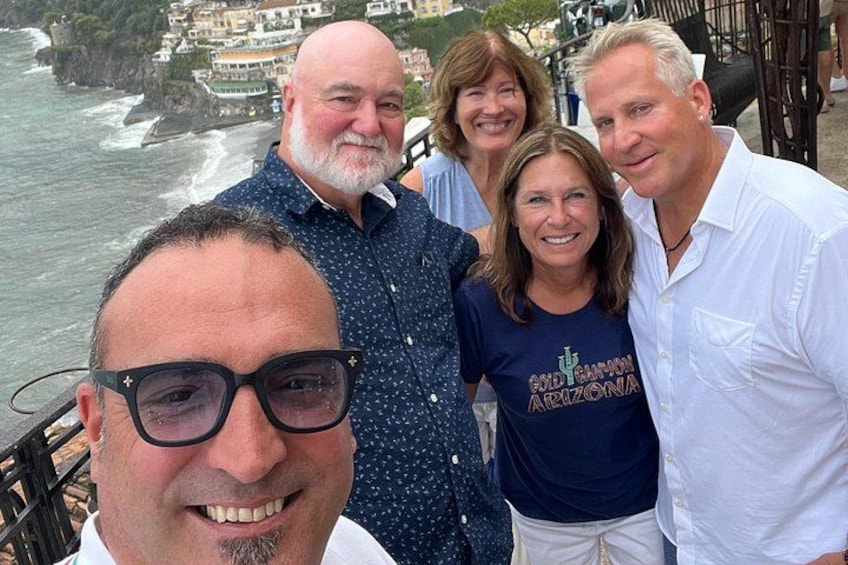 Un gruppo di persone in piedi su un ponte con vista sulla costa. 5