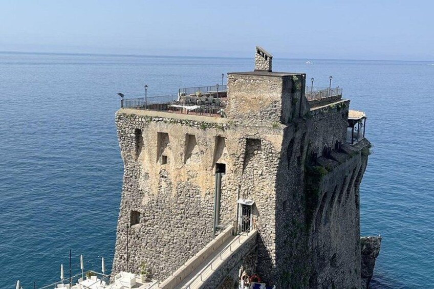 Una torre in pietra con una scala che scende verso l'acqua. 3