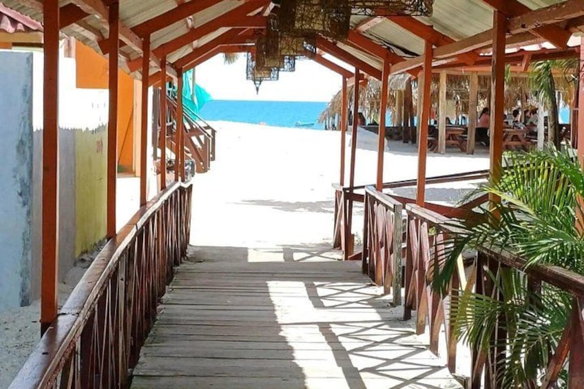 A wooden walkway leading to a beach with a clear view of the ocean. 4