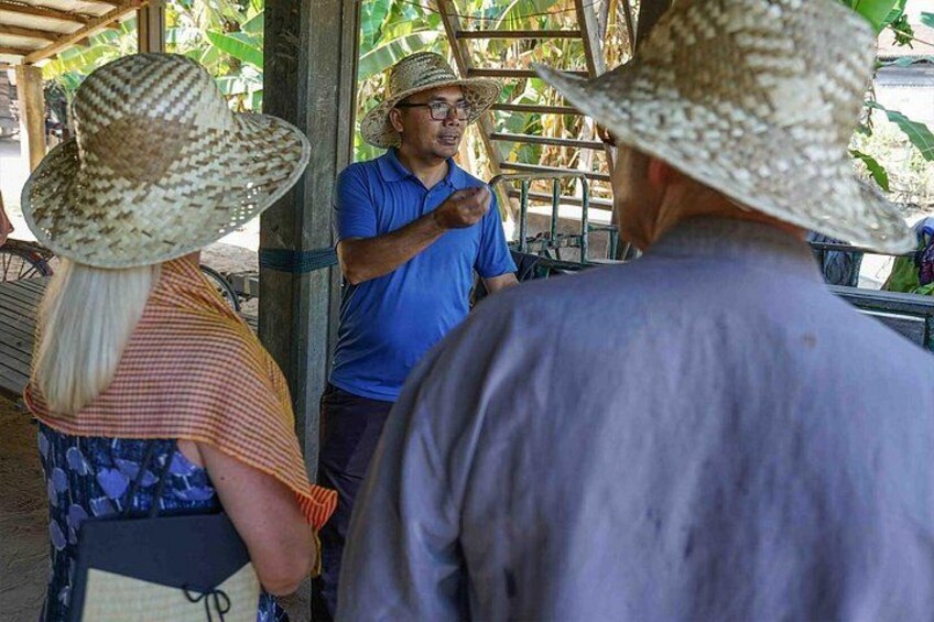 Personas con sombrero de paja y camisa azul de pie bajo un refugio. 4
