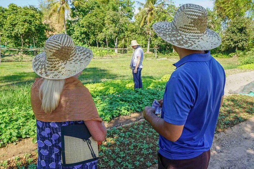 Dos personas con sombreros y un hombre trabajando en un campo a lo lejos. 1