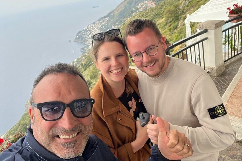 Trois personnes se tiennent sur un balcon d’où l’on peut admirer un paysage côtier. 4