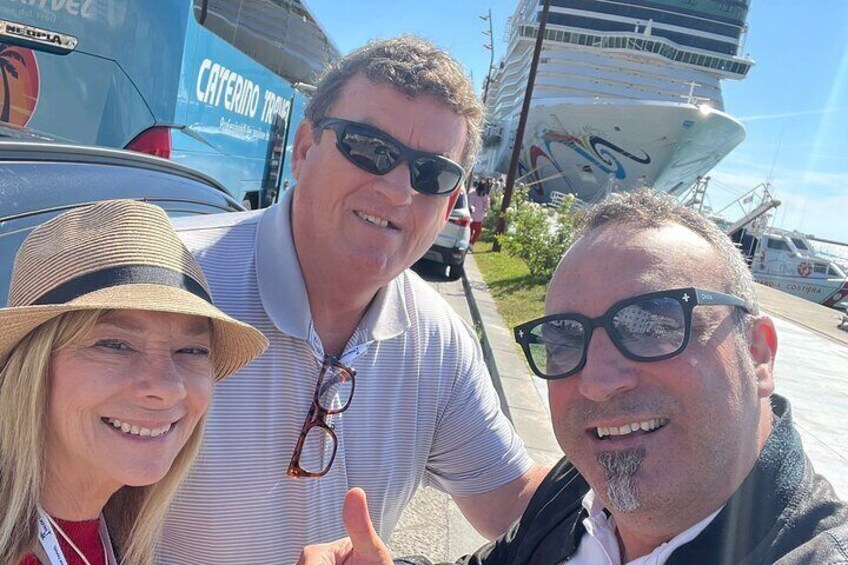 Trois personnes se trouvent à proximité d’un navire de croisière sur lequel on peut lire les mots « CATERING TRAVEL ». 3