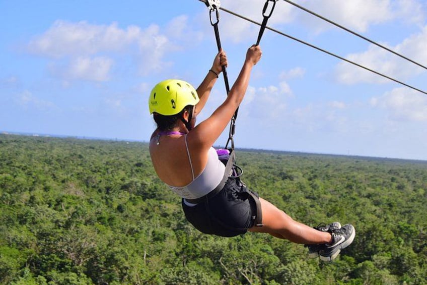 A person zip-lining over a dense forest canopy. 5