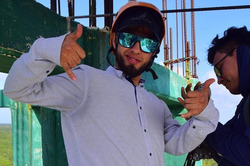 Two people wearing safety helmets and a construction site with green scaffolding. 4