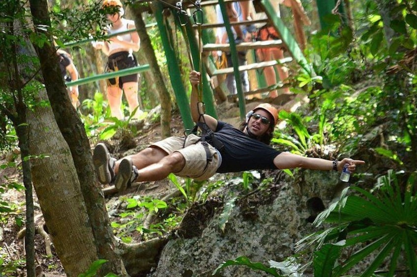 A person zip-lining through a forested area with ropes and trees. 3