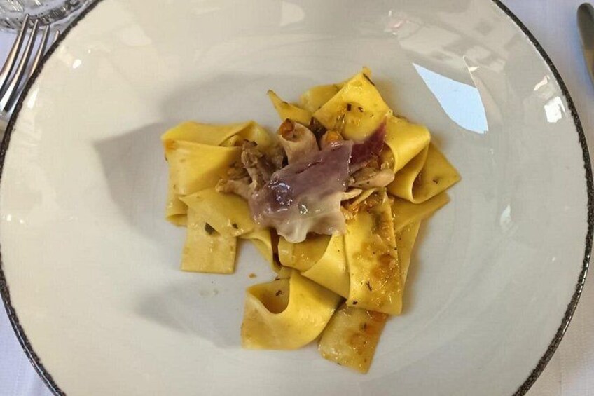 A plate of pasta with a piece of meat and sauce. 2
