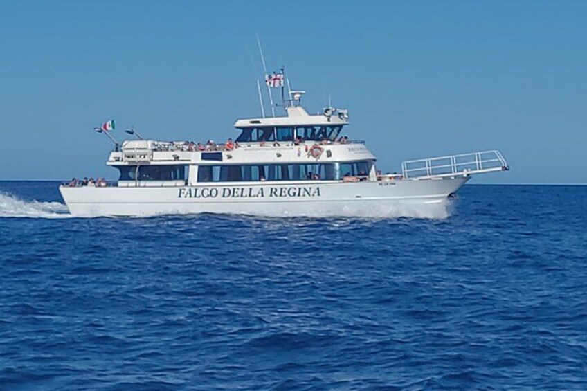 A white boat named 'Falco della Regina' on the water. 2