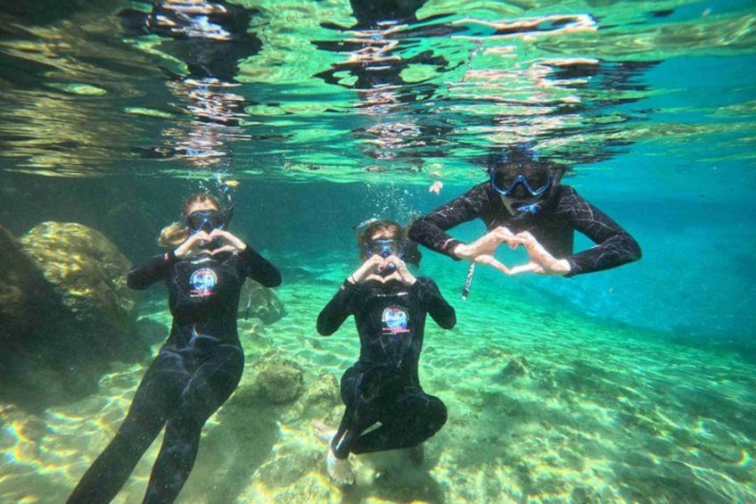 Three people scuba diving underwater. 2