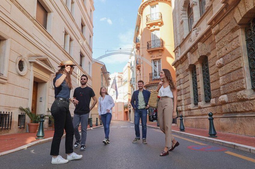 Un grupo de personas caminando por una calle estrecha bordeada de edificios. 3