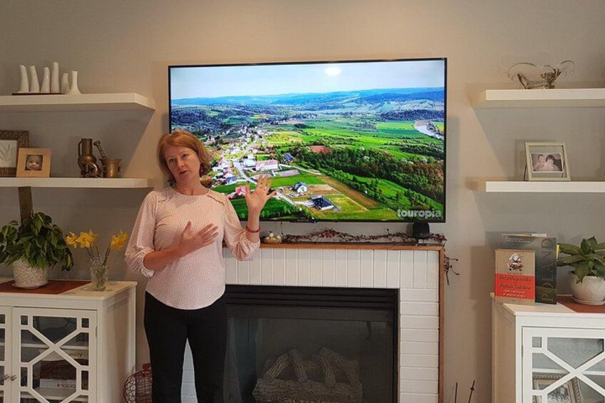 A woman standing in a living room with a television displaying a landscape. 1