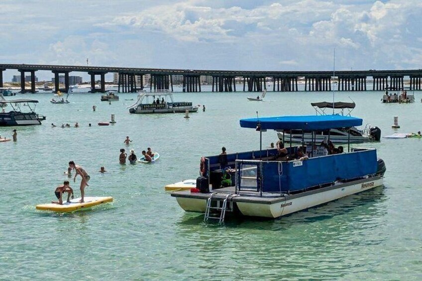 A pier with boats, people swimming, and a clear sky. 4