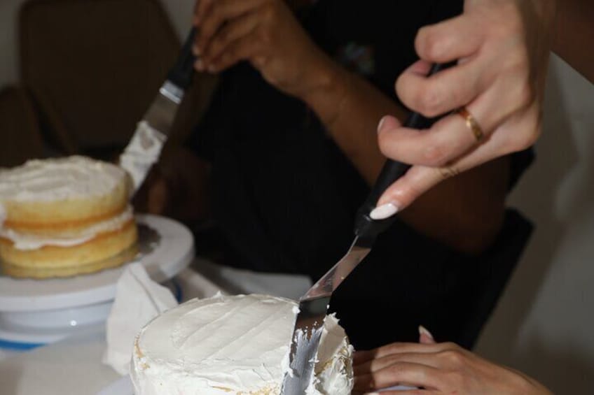 Learning how to apply a crumb coat to cake. 1