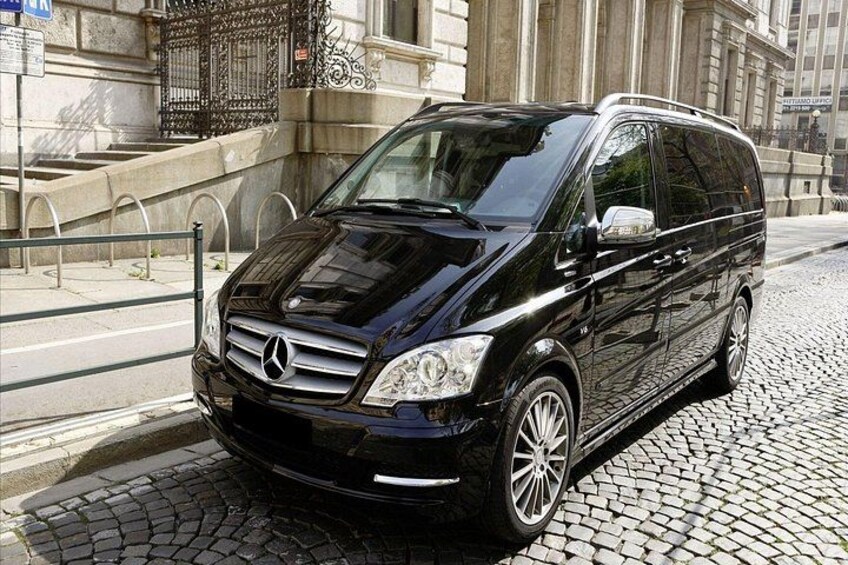 A black Mercedes-Benz van parked on a cobblestone street. 2