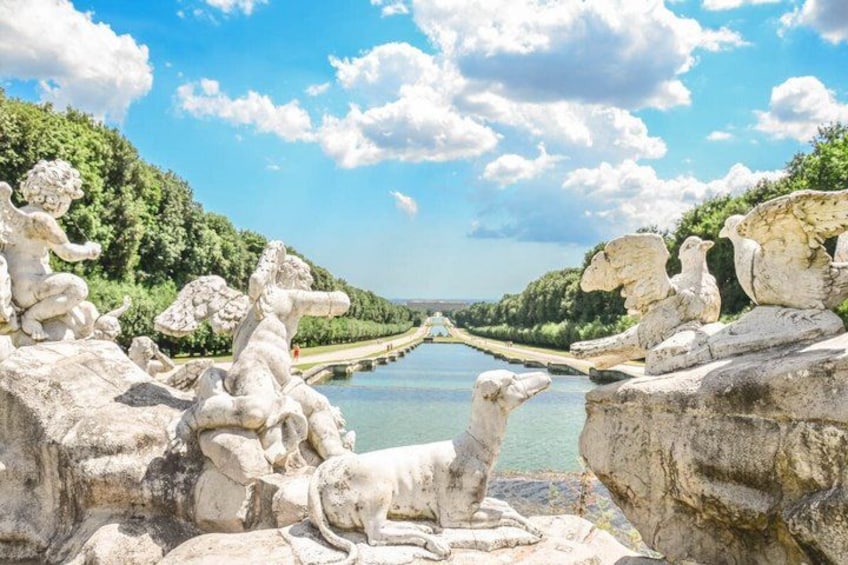 Un río con estatuas a orillas, cielo despejado y una vista distante de una ciudad. 4