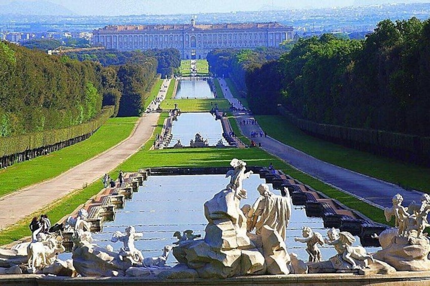 A grand palace with a long reflecting pool and statues. 1