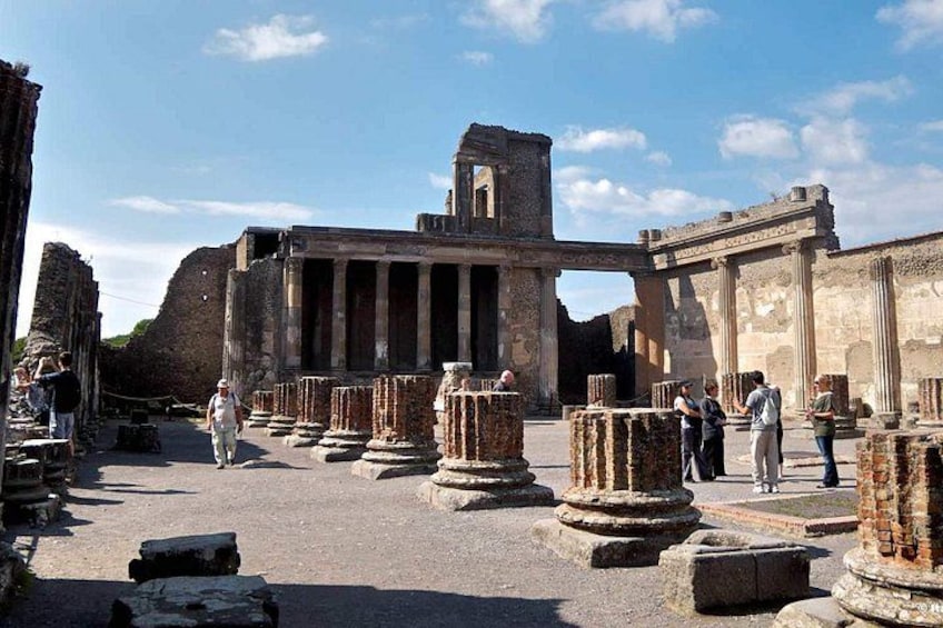 Ancient ruins with columns and a large stone structure. 4