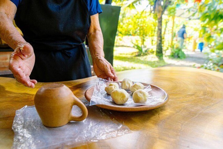A person placing dough balls on a plate, with a clay pot nearby. 4