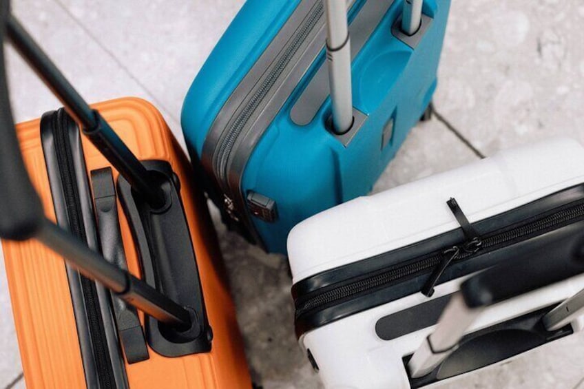 Three suitcases, one orange, one blue, and one white, with handles and zippers. 5