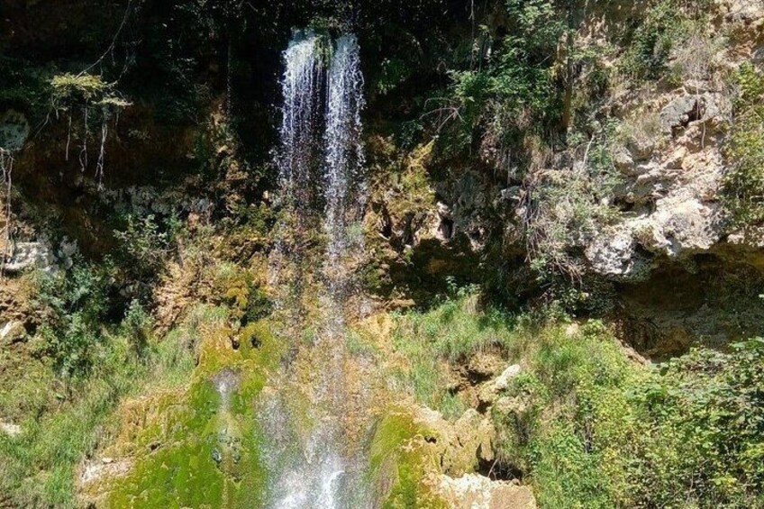 Una cascada se precipita por un acantilado rocoso, rodeado de vegetación. 2