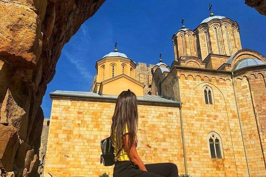 Una persona sentada frente a una iglesia bajo un cielo azul despejado. 3
