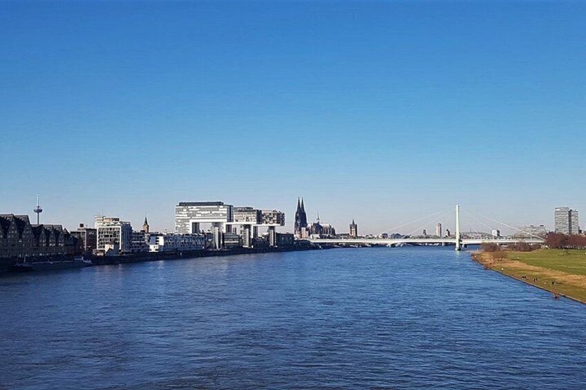 Een rivier met een brug, gebouwen en een toren. 1