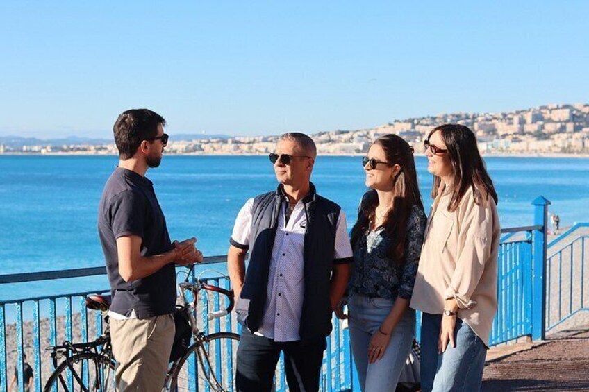 A group of people standing by a waterfront with bicycles and a railing. 4