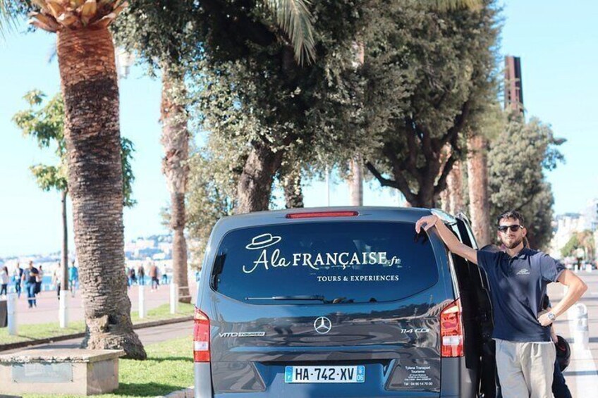 A car with 'Ala Francaise.fr' on the back, parked on a sunny street with palm trees and a clear sky. 5