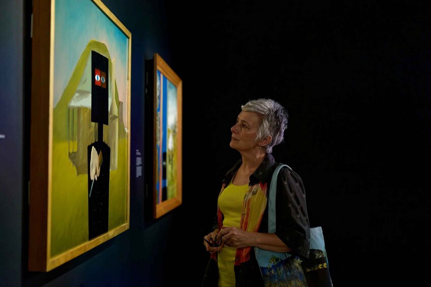 Henkilö, joka katselee maalauksia taidegalleriassa. 4