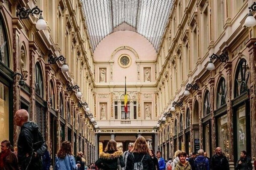 Un espacio interior concurrido y arquitectura ornamentada, que incluye un techo alto e iluminación decorativa. 3