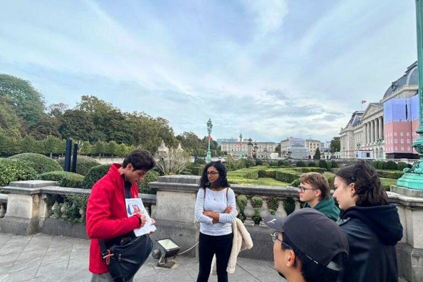 Un groupe de personnes se tient sur un pont, avec un parc et des bâtiments en arrière-plan. 4