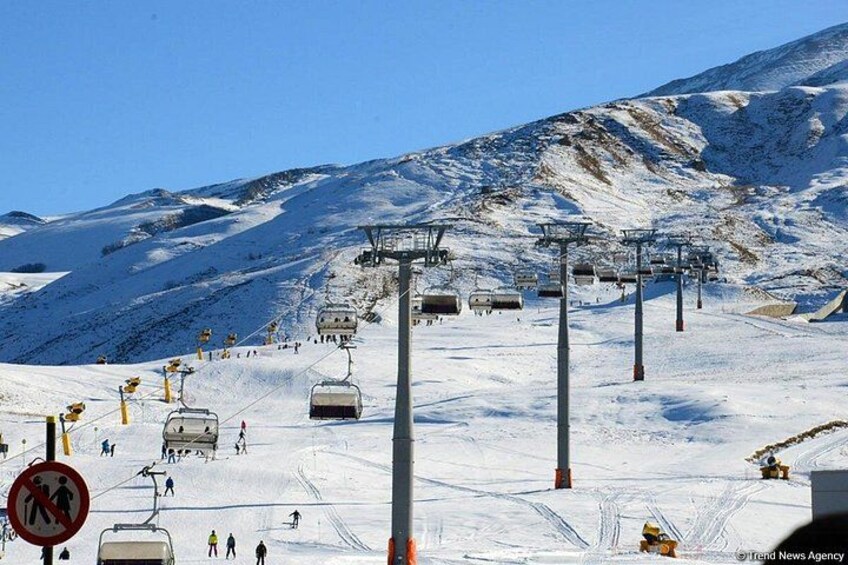 Une piste de ski avec un télésiège, un paysage enneigé et un ciel dégagé. 1