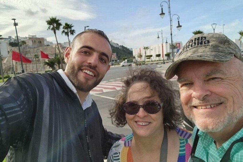 Three people taking a selfie with a street and buildings in the background. 4