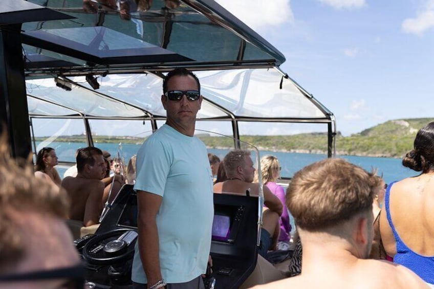A boat with people on board, a clear sky, and a body of water in the background. 5