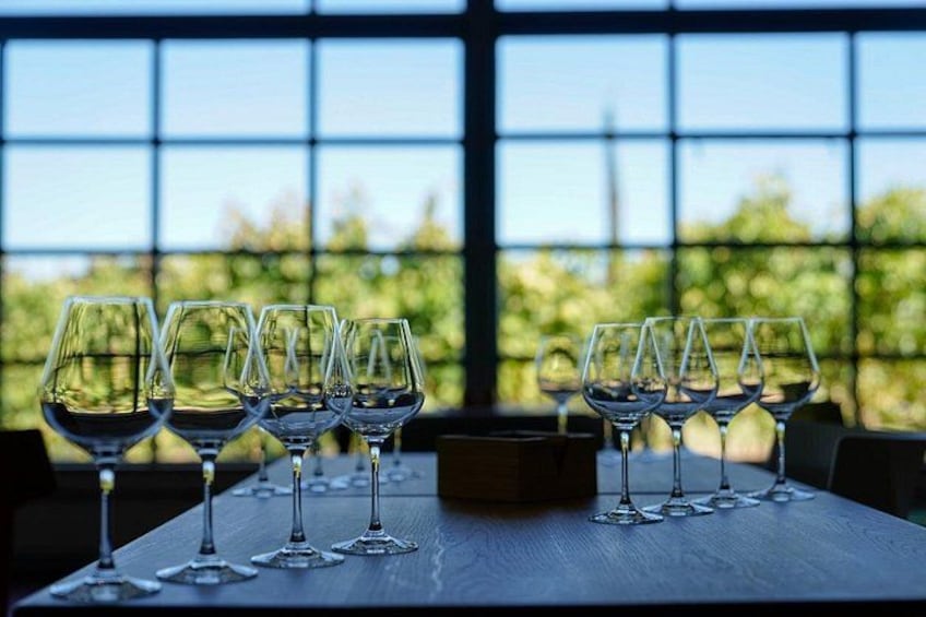 A table with empty wine glasses in a room with large windows. 1